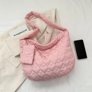 Detailed view of pink heart-quilted tote with matching small pouch and soft fabric texture