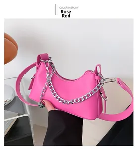 Détail du sac baguette rose rouge avec chaîne argentée et bandoulière en cuir réglable