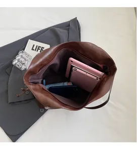 Interior view of brown leather tote bag showing large capacity for tablet and umbrella