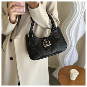 Detail of vintage black leather underarm bag featuring contrast white stitching and metal buckle