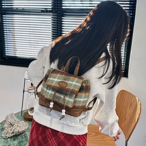Detail of checkered woolen backpack with leather flap and drawstring closure for women