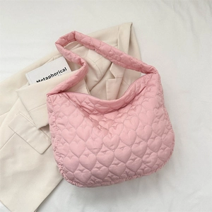 Detail of pink heart quilted tote bag with soft padded texture and shoulder strap