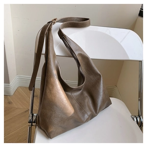 Detail shot showing the rich brown faux leather texture and golden buckle of the Hobo bag