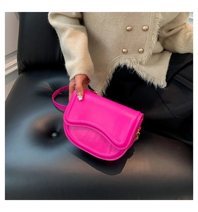 Detail of rose pink semi-circular saddle bag in glossy leather with wavy flap and gold zipper