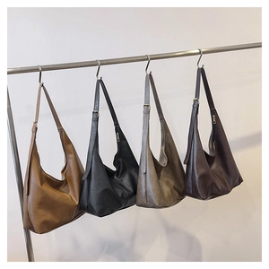 Four different colors of semi-circular leather shoulder bags displayed on hangers