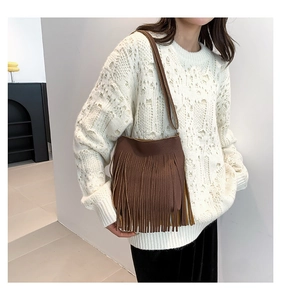 Close-up of deep brown crossbody bag with long fringe tassels and lychee grain leather