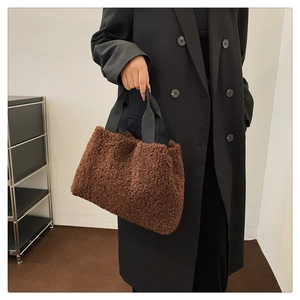 Close-up of brown faux shearling bucket bag with durable black nylon shoulder straps