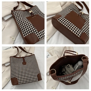 Detail of houndstooth bucket bag showing interior space, leather straps and base