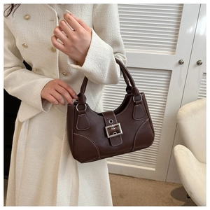 Close-up of vintage brown leather handbag with contrast stitching and silver buckle