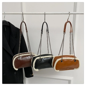 Detail of three cylindrical winter bags with faux shearling trim and metal chains