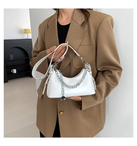 Gros plan d'un sac sous le bras blanc en PU avec chaîne argentée et breloque métallique