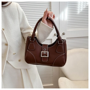 Detail of vintage brown handbag featuring white contrast stitching and silver buckle