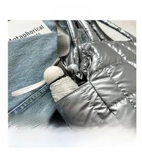 Silver quilted metallic handbag side pocket showing storage for a foldable umbrella
