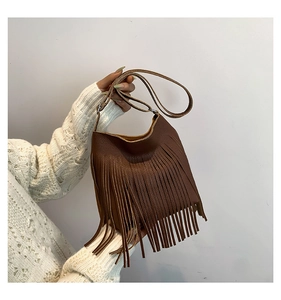 Detail of dark brown lychee leather texture and long fringe tassels on the shoulder bag