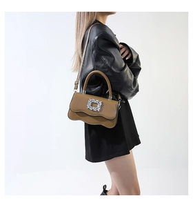 Détail d'un sac caramel avec une boucle en cristal et un design à bordure ondulée