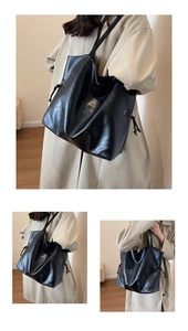 Detail view of large black faux leather bucket bag with drawstrings and glossy finish