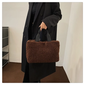 Detail of soft dark brown faux shearling tote bag with black woven handles for women