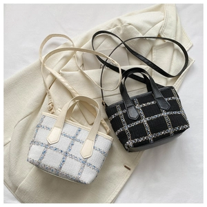 Detailed close-up of plaid tweed fabric textures on black and white mini tote bags