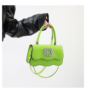 Détail du sac à main vert à bords ondulés avec boucle en cristal et cuir PU brillant