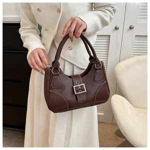 Detailed close-up of dark brown matte leather handbag with white contrast stitching
