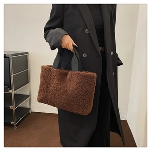 Close-up of brown fuzzy fleece tote bag with wide black strap for autumn fashion