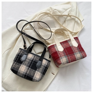 Close-up of two mini plaid tote bags in black and red tweed with leather handles