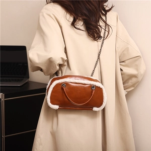 Brown leather shoulder bag with white faux fur trim and metal chain strap for winter fashion
