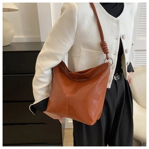 Detail of hobo shoulder bag featuring smooth brown leather and knotted strap design