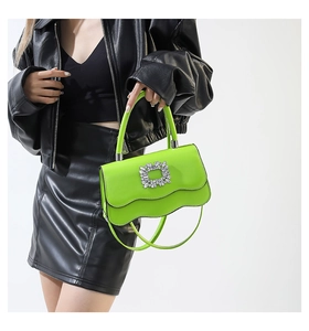 Détail du sac à main vert fluo à bord ondulé avec boucle en cristal sur cuir