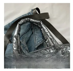 Detail view of the silver quilted tote bag showing adjustable nylon shoulder strap
