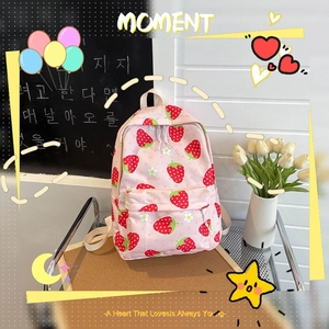 Pink student backpack with strawberry prints and white straps in a school setting
