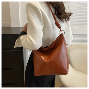 Detail of brown hobo bag showing creative leather knot and silver metal ring hardware