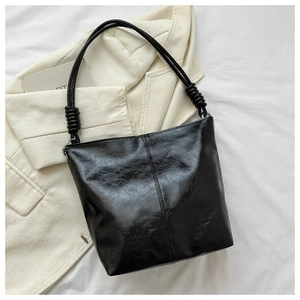 Detail of glossy pleated leather shoulder bag with knot straps and silver rings