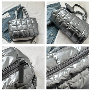 Detail view of silver quilted down tote bag showing metallic texture and zippers