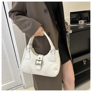 White hobo handbag with silver buckle shown on shoulder of model in office setting