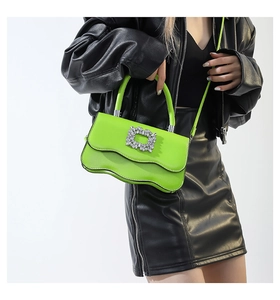 Détail du sac vert fluo à bords ondulés avec boucle en cristal et cuir métallisé