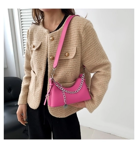 Vue détaillée de la chaîne en métal argenté et de la texture cuir fuchsia du sac chic