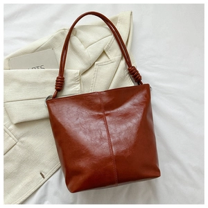 Detailed view of vintage brown tote bag with unique knot decoration and vertical stitching