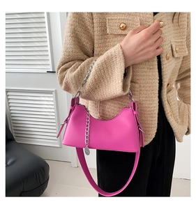 Détail du sac à main croissant rose vif avec chaîne argentée et bandoulière réglable