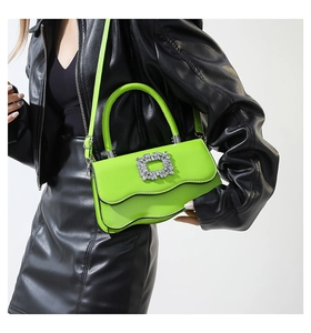 Détail du sac vert néon à bord ondulé avec boucle en cristal et texture lisse élégante