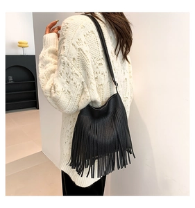 Close-up of black fringe shoulder bag showing lychee grain leather texture and tassels