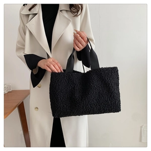 Detail of black faux fur tote bag showing plush texture and casual strap on model