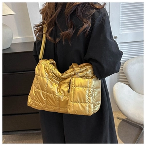 Detail of gold quilted tote bag with matching mini pouch and metal luster finish