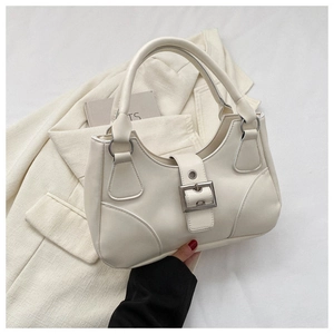 Detailed shot of beige handbag with large silver buckle and smooth matte leather finish