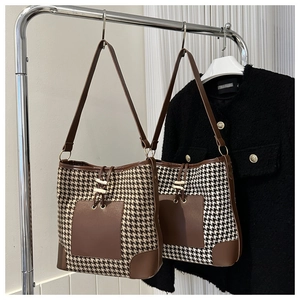 Detail of vintage houndstooth shoulder bag with brown leather trim and drawstring closure