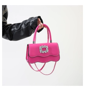 Détail du sac en cuir fuchsia avec rabat ondulé et boucle carrée en strass brillants