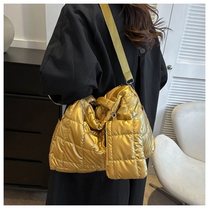 Detailed view of gold quilted puffer tote bag with a small matching zip coin purse pendant