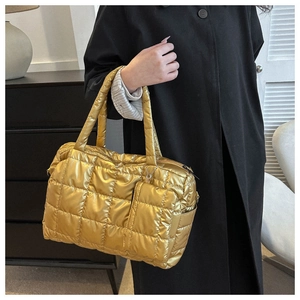 Detail of metallic gold quilted puffer tote bag with matching coin purse on black coat