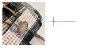 Macro shot of a FEIMU leather brand tag on black and brown checkered wool fabric