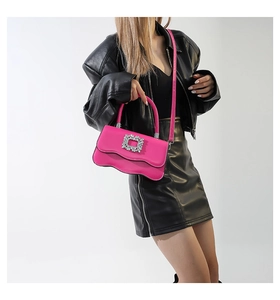 Détail du sac en cuir fuchsia avec base ondulée et boucle carrée en strass brillant